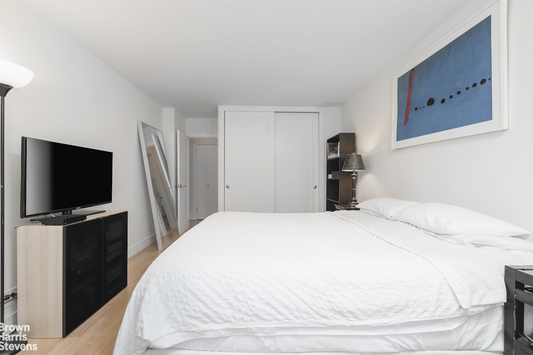 10 West 15th Street, Unit 1014 Manhattan, NY 10011 - Photo 12 of 19 a bedroom with a bed and a flat screen tv