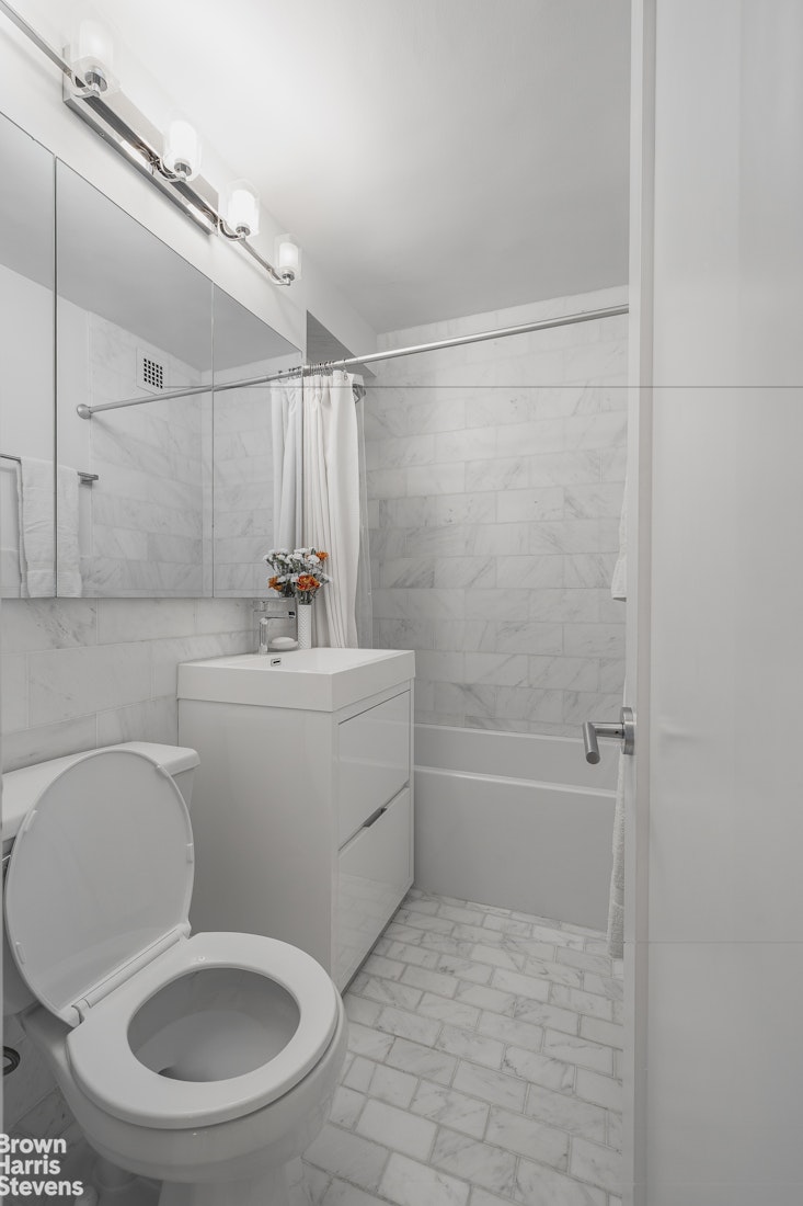 10 West 15th Street, Unit 1014 Manhattan, NY 10011 - Photo 17 of 19 a bathroom with a toilet a sink and bathtub