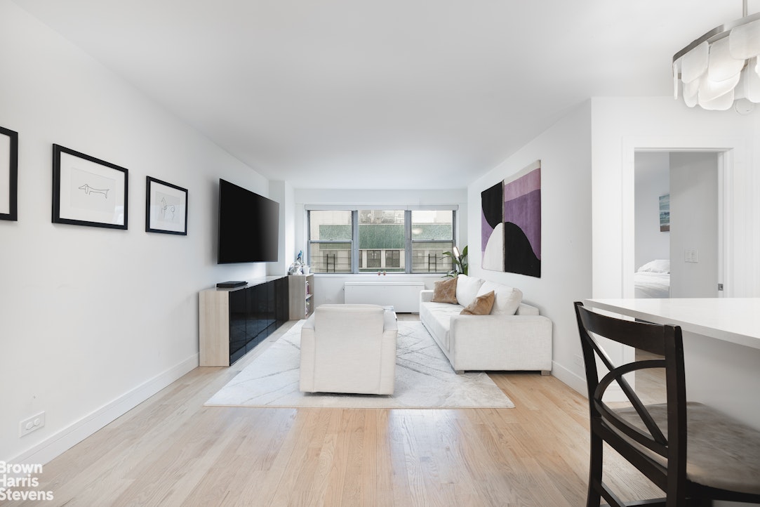 10 West 15th Street, Unit 1014 Manhattan, NY 10011 - Photo 2 of 19 a living room with furniture a flat screen tv and a fireplace