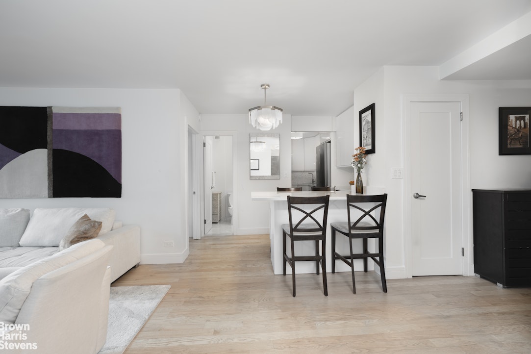 10 West 15th Street, Unit 1014 Manhattan, NY 10011 - Photo 5 of 19 a living room with furniture a dining table and a fireplace