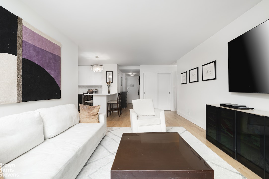 10 West 15th Street, Unit 1014 Manhattan, NY 10011 - Photo 7 of 19 a living room with furniture flat screen tv and a fireplace