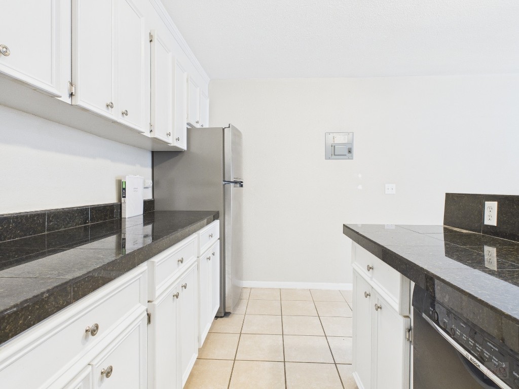 304 East 33rd Street, Unit 10 Austin, TX 78705 - Photo 11 of 28 a kitchen with granite countertop white cabinets and white appliances