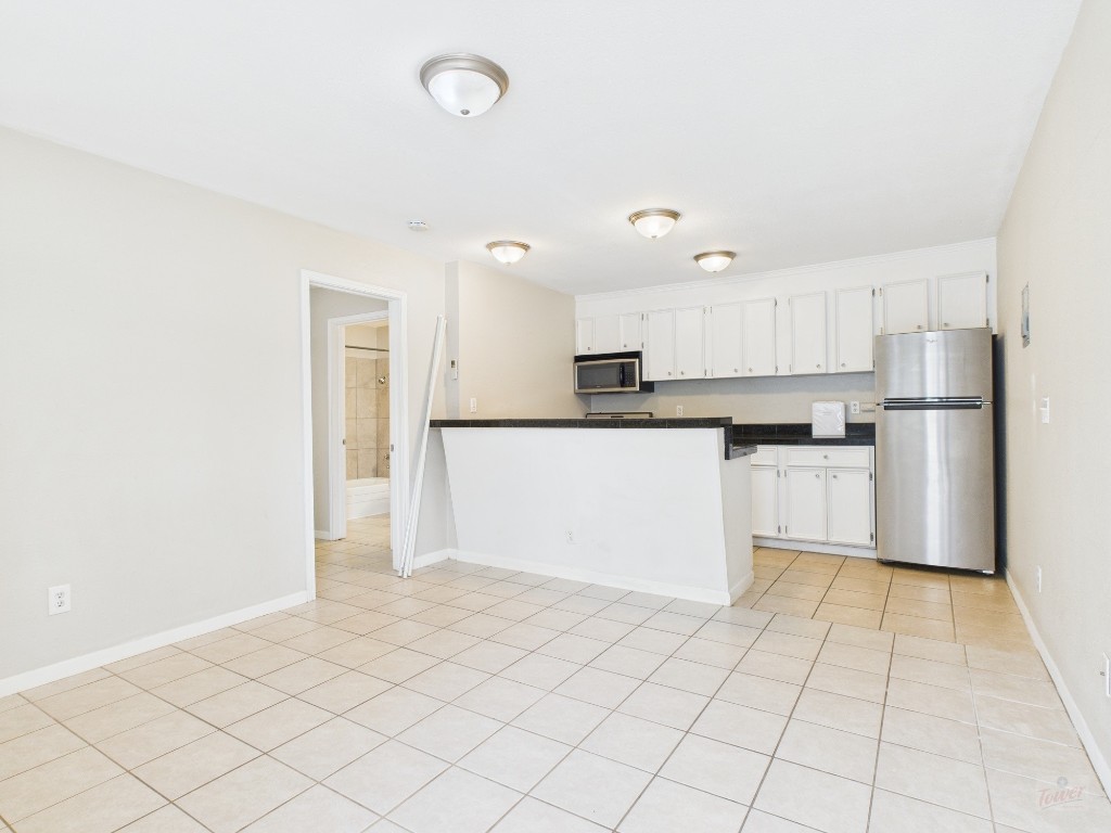 304 East 33rd Street, Unit 10 Austin, TX 78705 - Photo 2 of 28 a kitchen with granite countertop a refrigerator and a stove top oven