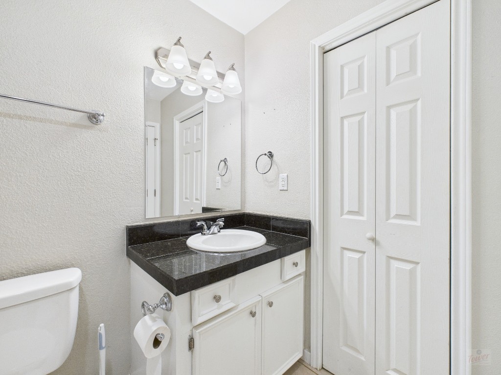 304 East 33rd Street, Unit 10 Austin, TX 78705 - Photo 22 of 28 a bathroom with a granite countertop sink a toilet and a mirror
