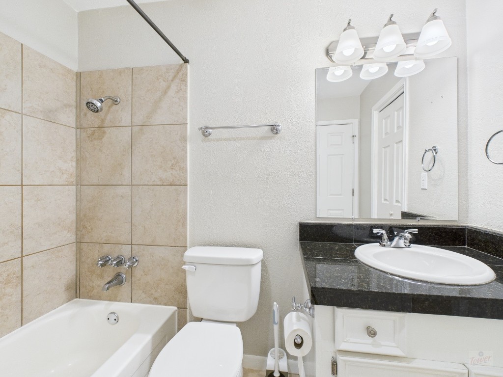 304 East 33rd Street, Unit 10 Austin, TX 78705 - Photo 23 of 28 a bathroom with a granite countertop sink mirror toilet and bathtub