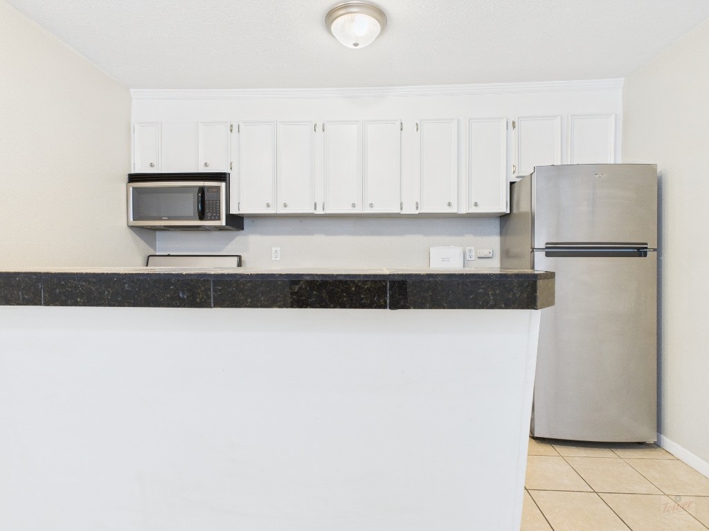 304 East 33rd Street, Unit 10 Austin, TX 78705 - Photo 6 of 28 a kitchen with a refrigerator and a stove
