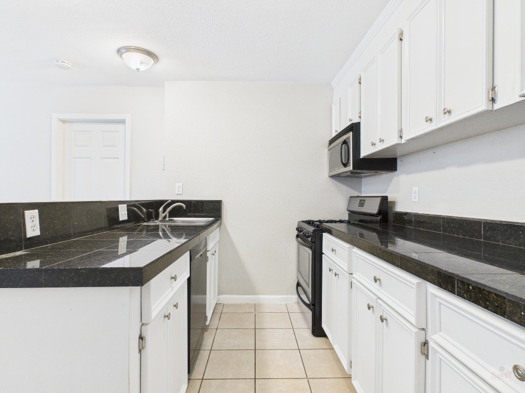 304 East 33rd Street, Unit 10 Austin, TX 78705 - Photo 8 of 28 a kitchen with granite countertop a sink and a stove