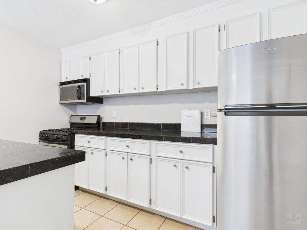 304 East 33rd Street, Unit 10 Austin, TX 78705 - Photo 9 of 28 a kitchen with white cabinets and refrigerator