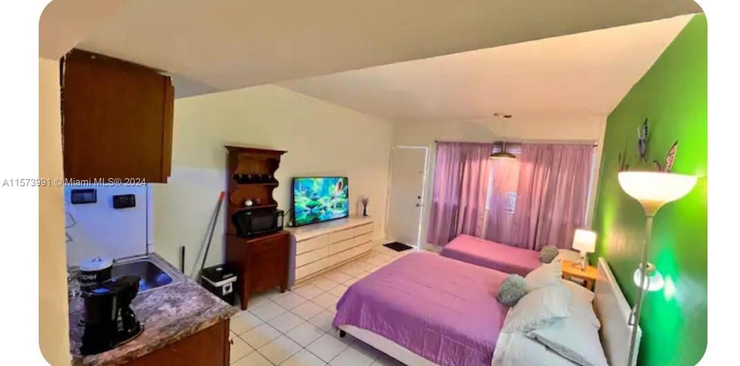 a bed room with a bed and a television
