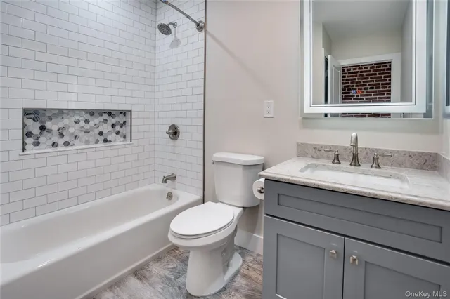 a bathroom with a granite countertop toilet sink and bathtub