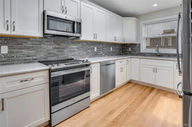 a kitchen with granite countertop a stove top oven microwave and cabinets