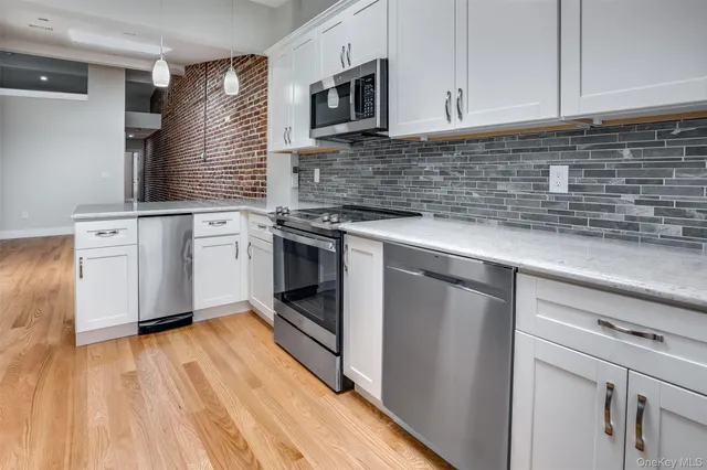 a kitchen with stainless steel appliances granite countertop a sink a stove and cabinets