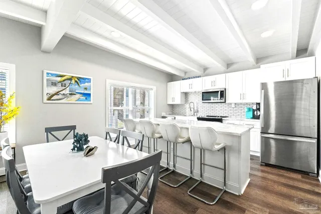 a kitchen with stainless steel appliances a white table and chairs in it