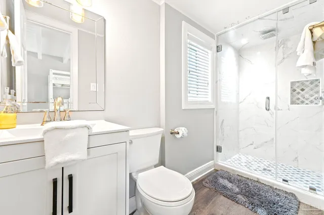 a bathroom with a sink a toilet and shower