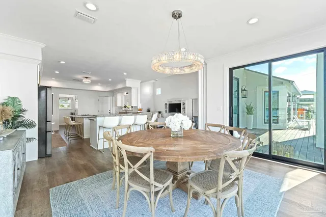 a view of a dining room and livingroom with furniture wooden floor a chandelier