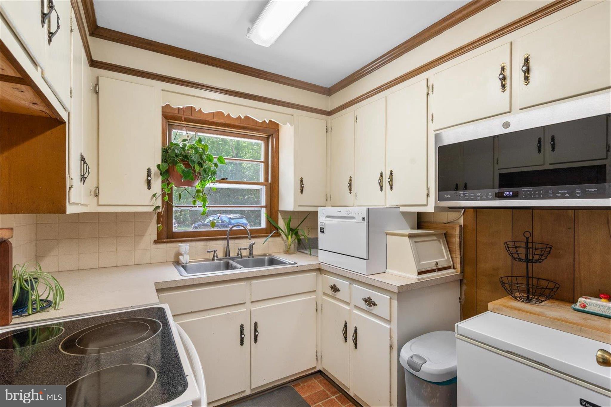 5150 Campground Road Eden, MD 21822 - Photo 9 of 43 a kitchen with a stove a sink dishwasher and white cabinets with wooden floor