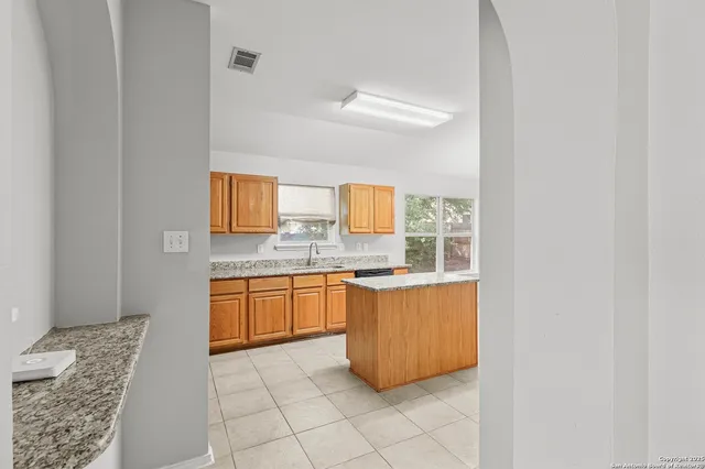 a large bathroom with a granite countertop sink a mirror and a bathtub