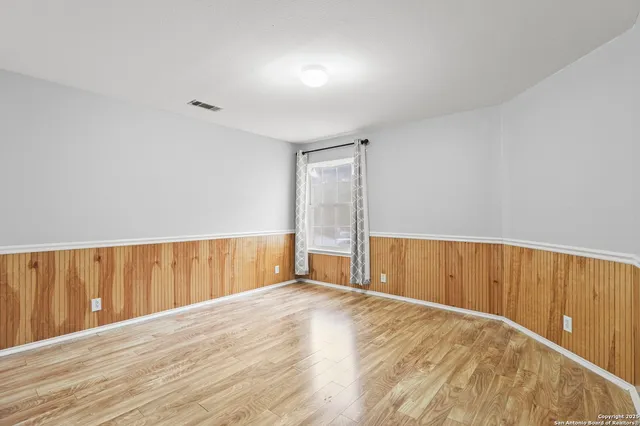 a view of an empty room with wooden floor