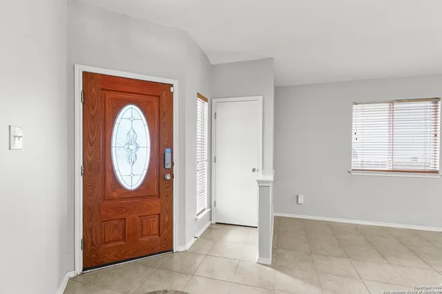 an entryway with wooden floor a mirror and a window
