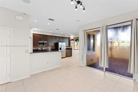 a large white kitchen with a refrigerator a stove a sink and a window