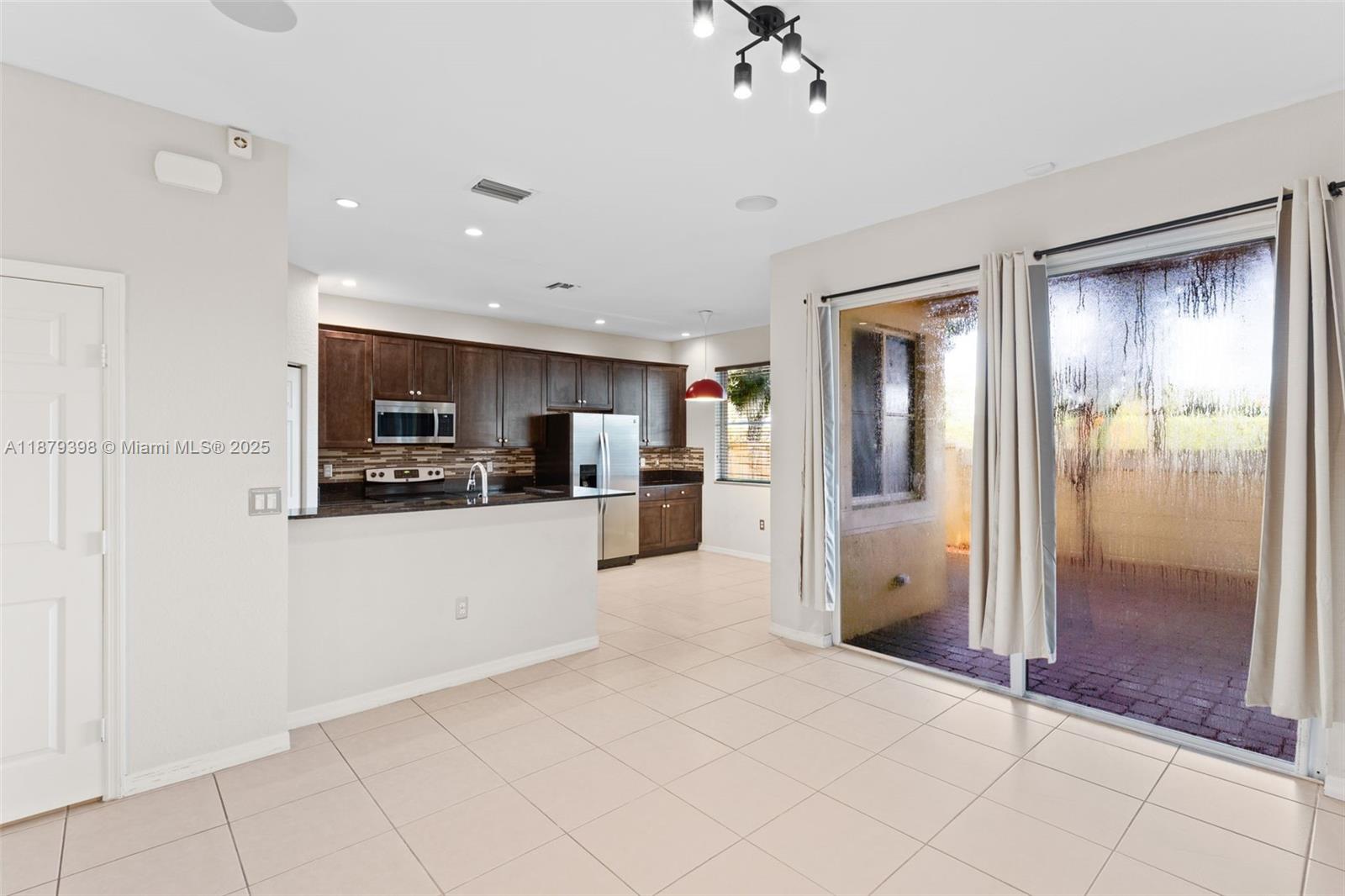 9035 Southwest 17th Court Miramar, FL 33025 - Photo 13 of 39 a large white kitchen with a refrigerator a stove a sink and a window