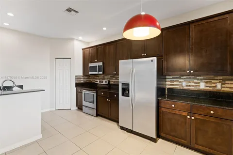 a kitchen with stainless steel appliances granite countertop a refrigerator and a sink