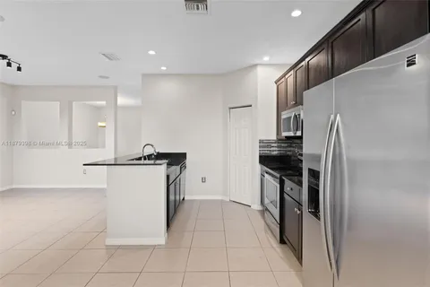 a kitchen with stainless steel appliances granite countertop a refrigerator and a stove