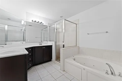 a bathroom with a double vanity sink mirror and bathtub