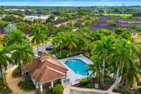 an aerial view of residential houses with outdoor space and trees all around