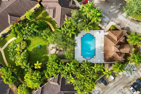 an aerial view of residential houses with outdoor space and trees