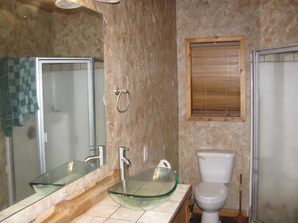941 North 4420th Road Valliant, OK 74764 - Photo 17 of 40 a bathroom with a toilet and a shower