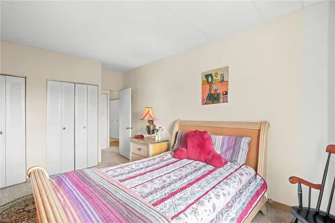 a bedroom with a bed and a view of kitchen
