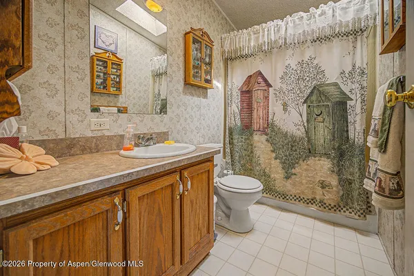 a bathroom with a granite countertop sink toilet and shower