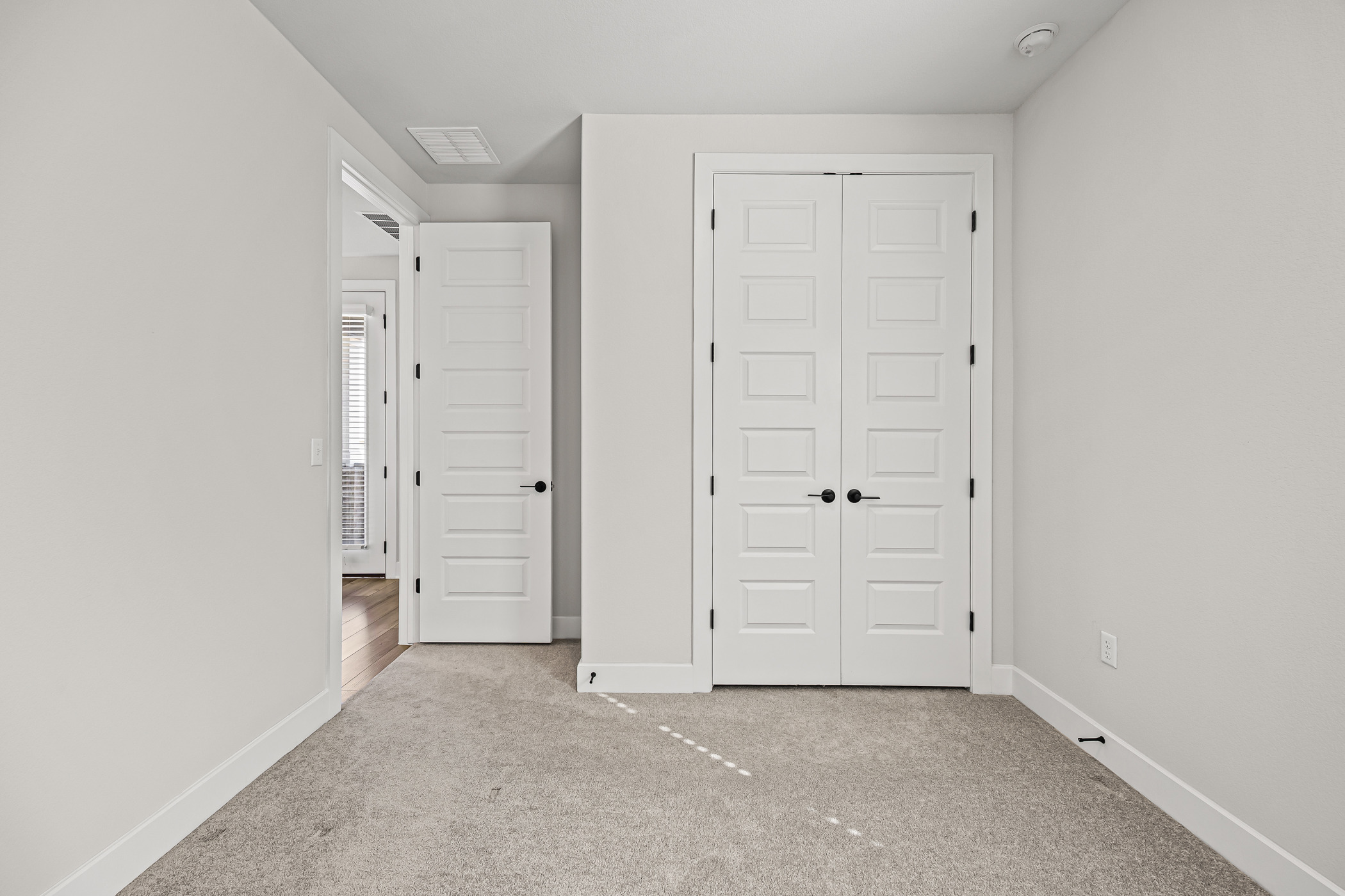 5806 Rangeland Road Austin, TX 78747 - Photo 25 of 34 A well-lit room with fresh carpet and crisp white doors offers a welcoming, clean aesthetic.
