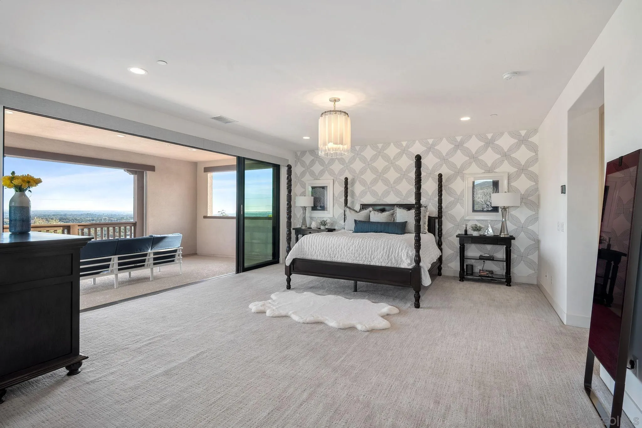 3801 Rancho Summit Drive Encinitas, CA 92024 - Photo 6 of 10 a spacious bedroom with a bed a table and flat screen tv