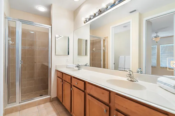 a bathroom with a double vanity sink a large mirror and a shower