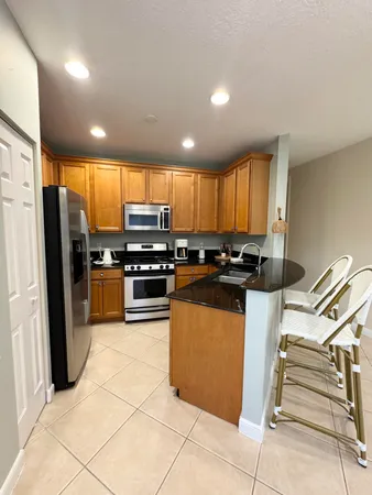 a kitchen with stainless steel appliances granite countertop a refrigerator and a stove top oven