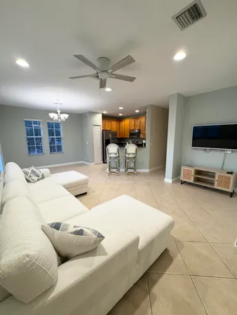a spacious bedroom with a bed a couch and a flat tv screen on the dresser