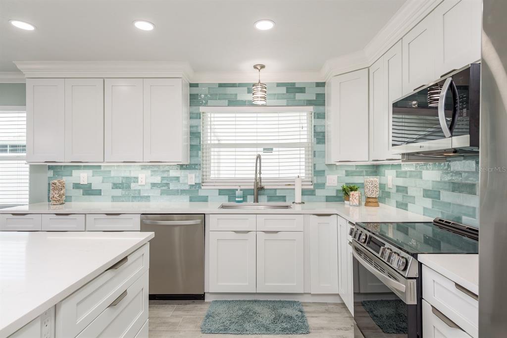 3301 Seaway Drive New Port Richey, FL 34652 - Photo 15 of 53 a kitchen with a sink stove and cabinets