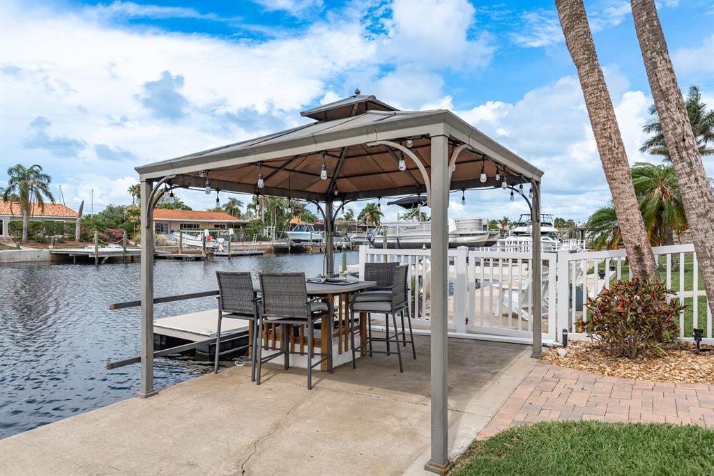 3301 Seaway Drive New Port Richey, FL 34652 - Photo 36 of 53 a view of a patio with table and chairs under an umbrella