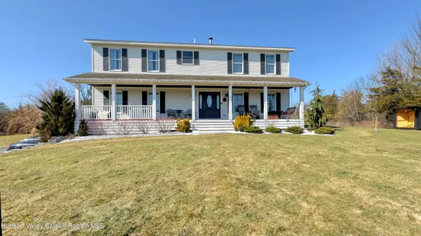 a view of a house with large windows and a small yard