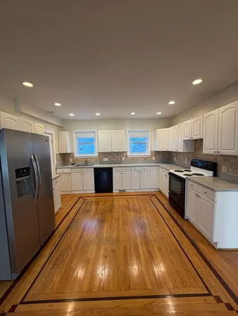 a large kitchen with stainless steel appliances granite countertop a refrigerator and a stove top oven