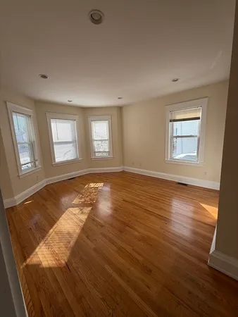 a view of a room with wooden floor and window