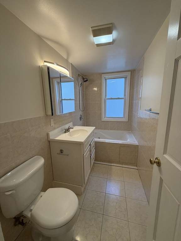 555 Heath Street, Unit 1 Brookline, MA 02467 - Photo 4 of 7 a bathroom with a toilet a sink a mirror and a bathtub