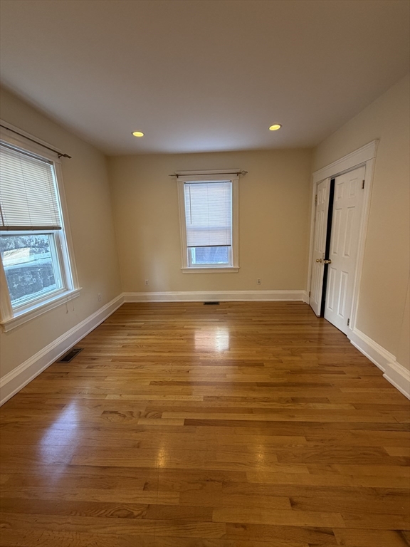 555 Heath Street, Unit 1 Brookline, MA 02467 - Photo 5 of 7 a view of empty room with wooden floor and fan