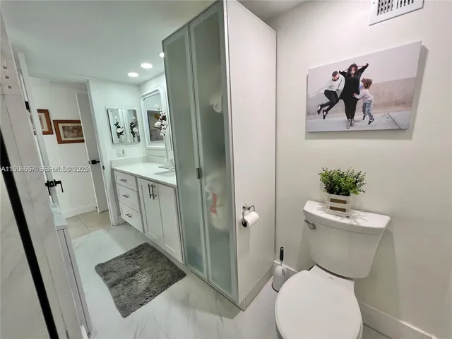 a white toilet sitting next to a bathroom sink
