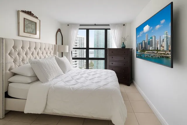 a bedroom with a bed next to a window with outer view