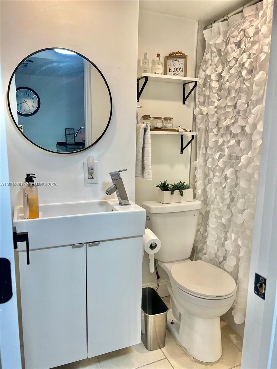 600 Northeast 36th Street, Unit 2011 Miami, FL 33137 - Photo 15 of 49 a bathroom with a toilet a sink and a mirror