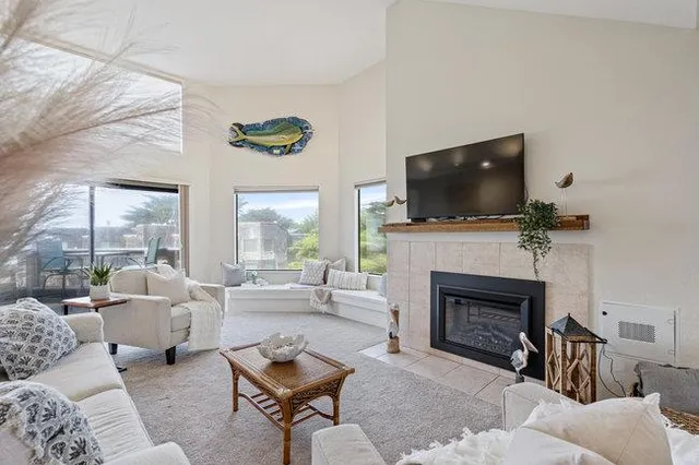 a living room with furniture a fireplace and a flat screen tv