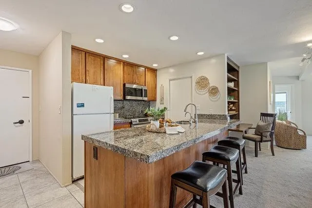 a kitchen with granite countertop a stove top oven microwave and cabinets